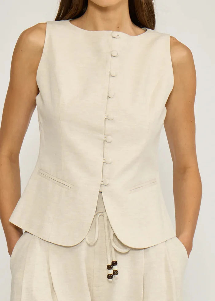 Cream sleeveless vest top with button front closure and drawstring waist detail on matching pants.