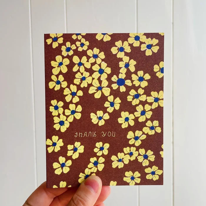 Card with yellow floral pattern and 'I love you' text held against a white background