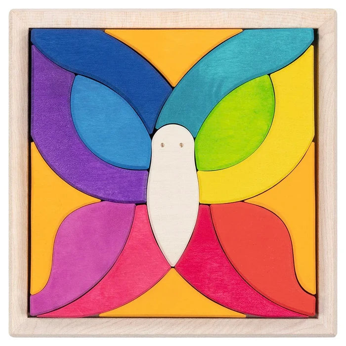 Goki Butterfly Mariposa Tile Puzzle fully assembled in its natural wood square frame, showing 15 rainbow-colored maple wood pieces arranged to form a symmetrical butterfly with a white body piece at center, surrounded by curved wing pieces in purple, blue, teal, green, yellow, orange, pink, and red on an orange background