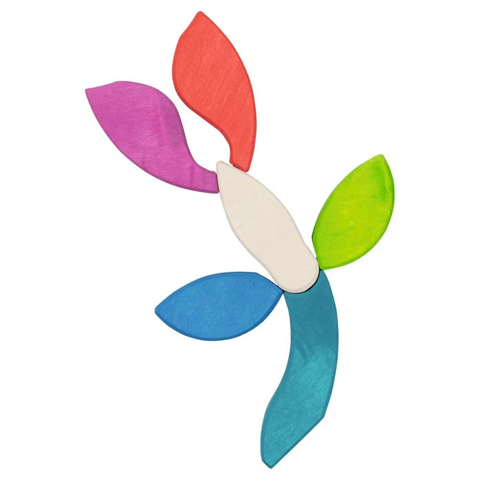 Goki Butterfly Mariposa Tile Puzzle pieces arranged in free play as a flower or leaf shape, with the white body piece at center and leaf-shaped pieces radiating outward in pink, red, green, blue, and teal on a white background