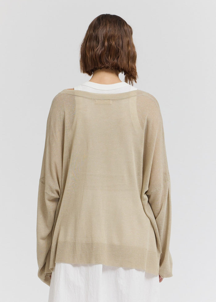 Beige oversized knit top with white ribbed crew neckline, shown from back view.