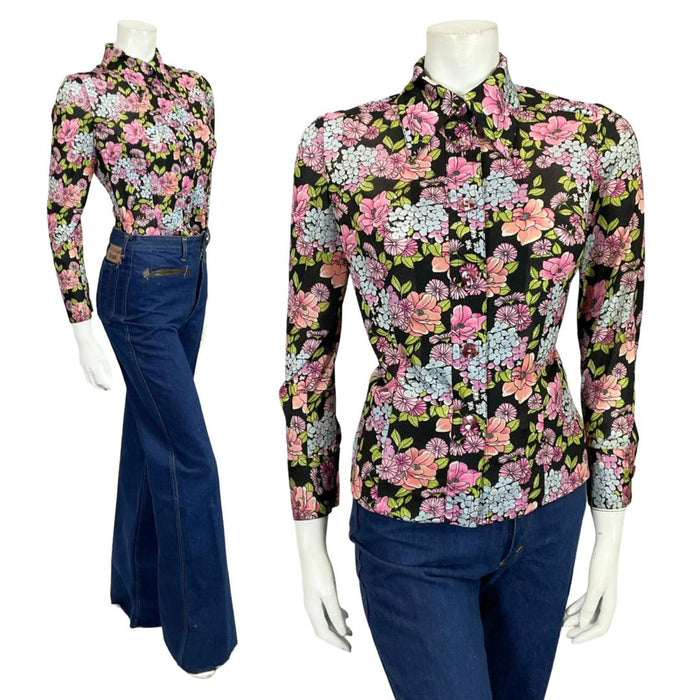Mannequin wears a black blue and pink floral mod 60s 70s dagger collar shirt with blue flared jeans.