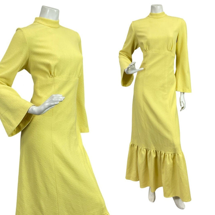 Mannequin wears a 60s 70s bright yellow bell sleeve maxi dress with a funnel neck and ruffled hemline.