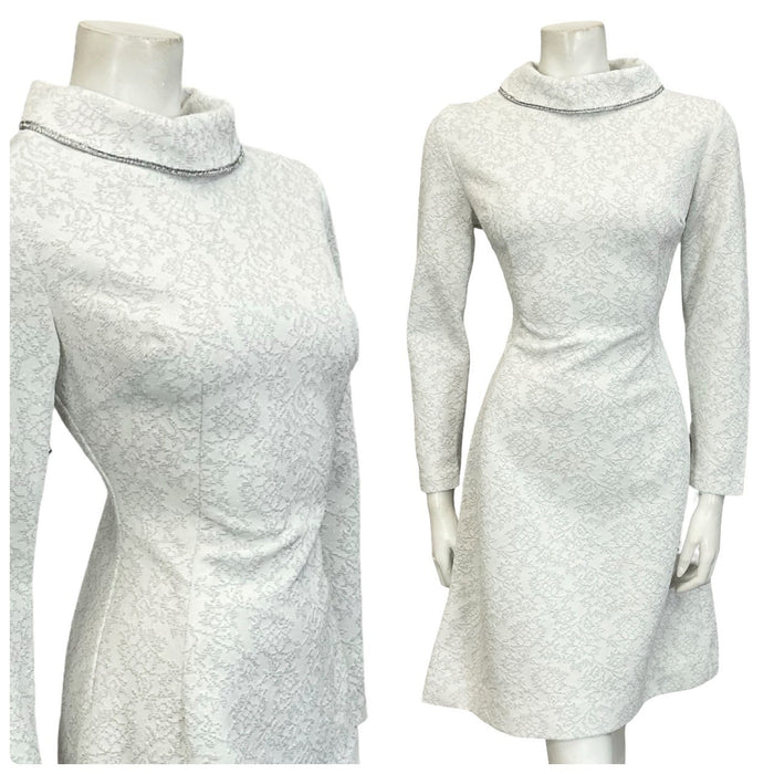 Mannequin wears a white and silver 60s 70s glittery long sleeve funnel neck mini dress