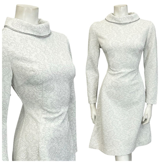 Mannequin wears a white and silver 60s 70s glittery long sleeve funnel neck mini dress