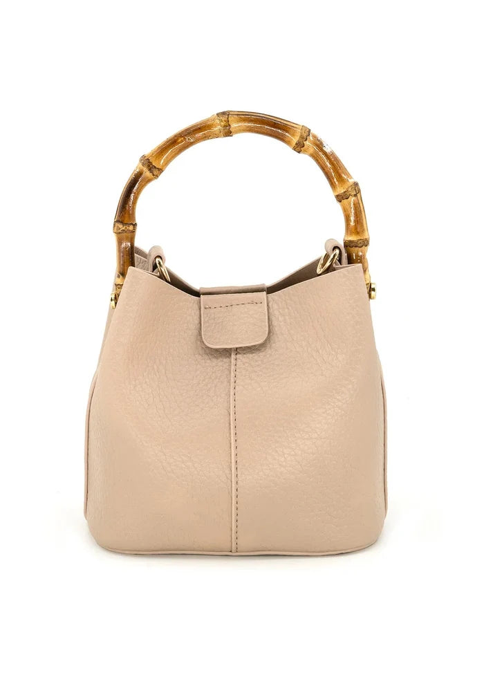 Beige bucket handbag with bamboo handles and front flap closure.