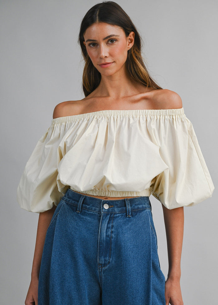 Cream off-the-shoulder top with puffed sleeves and elasticized neckline and waistband.