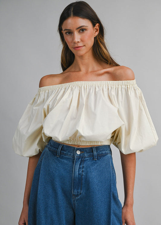 Cream off-the-shoulder top with puffed sleeves and elasticized neckline and waistband.