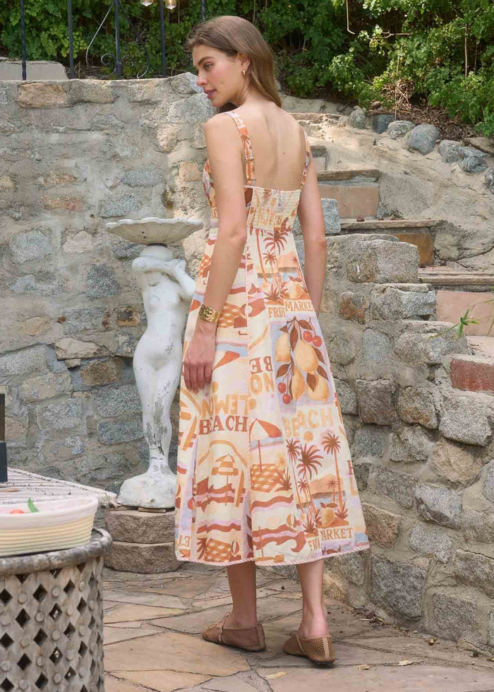 Sleeveless midi dress with orange and cream beach-themed print, open back design, shown from rear view.