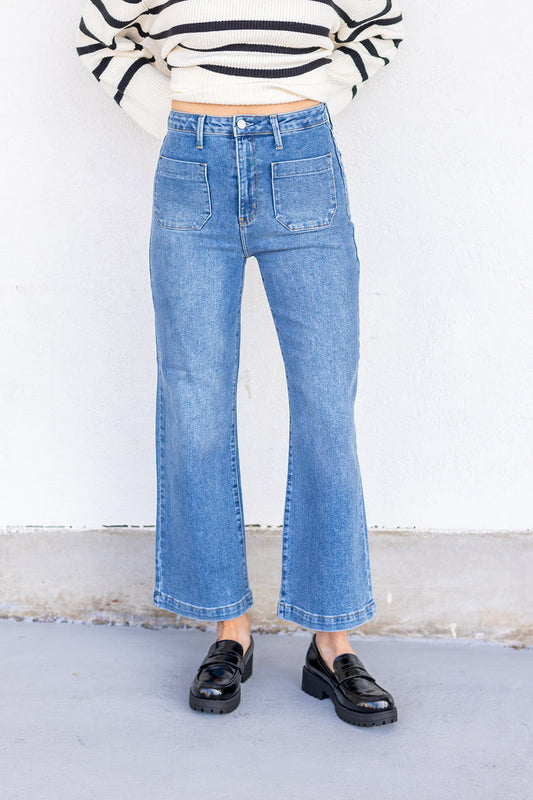 Medium blue denim jeans with high waist, front patch pockets, and cropped flare leg.