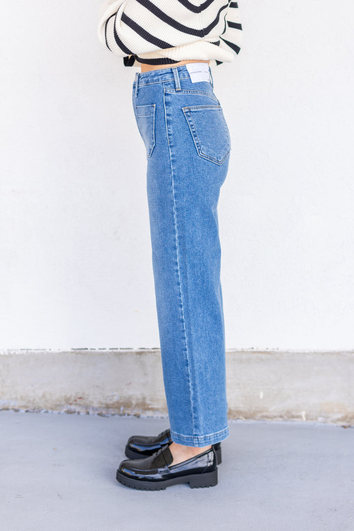Blue denim jeans with high waist and straight leg fit, shown from side view.